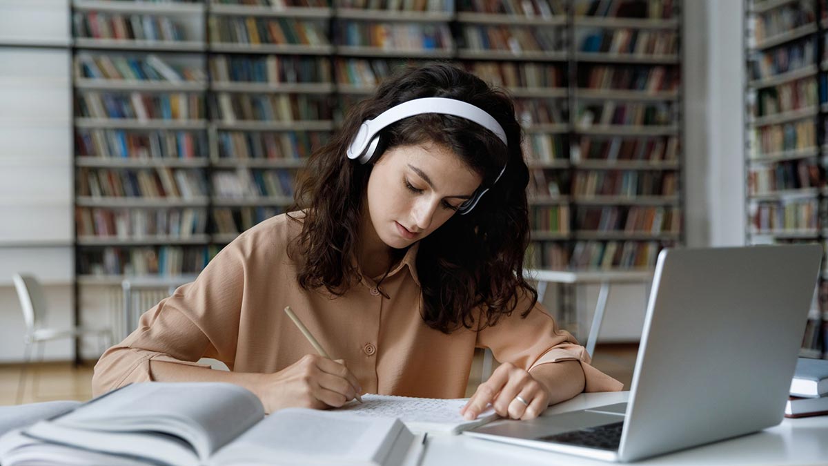 A medical school student using UWorld to study for the USMLE Step 2 CK in a library in front of a laptop.